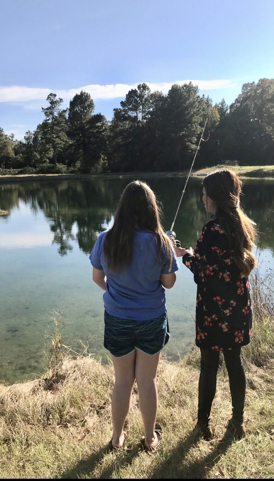 My cousin and wife fishing at a pond